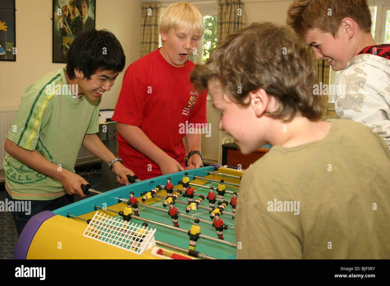 Jungs spielen Tischfußball in der Freizeit im Internat. Stockfoto