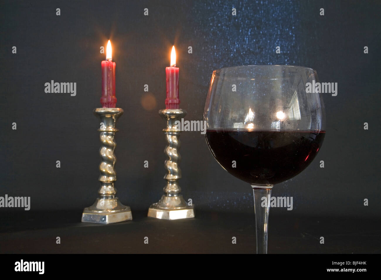 brennende Kerzen, ein Glas roten Pino Noir Wein, in einer romantischen situation Stockfoto