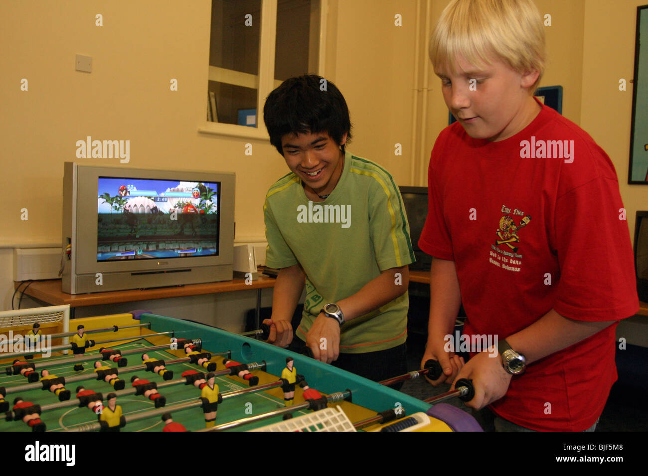 Jungs spielen Tischfußball in der Freizeit im Internat. Stockfoto