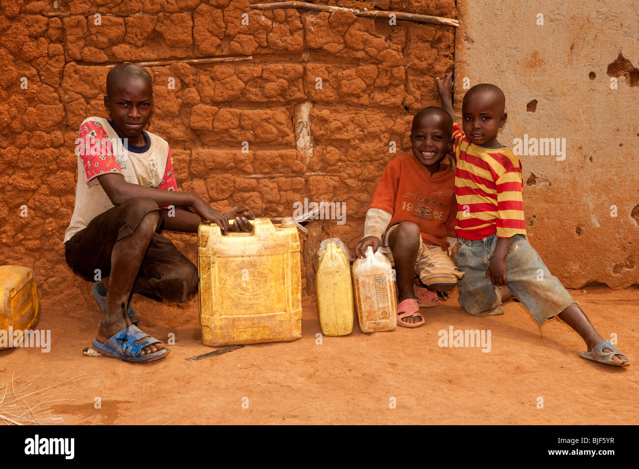 Kinder sammeln von Wasser aus Brunnen und nach Hause tragen. Stockfoto