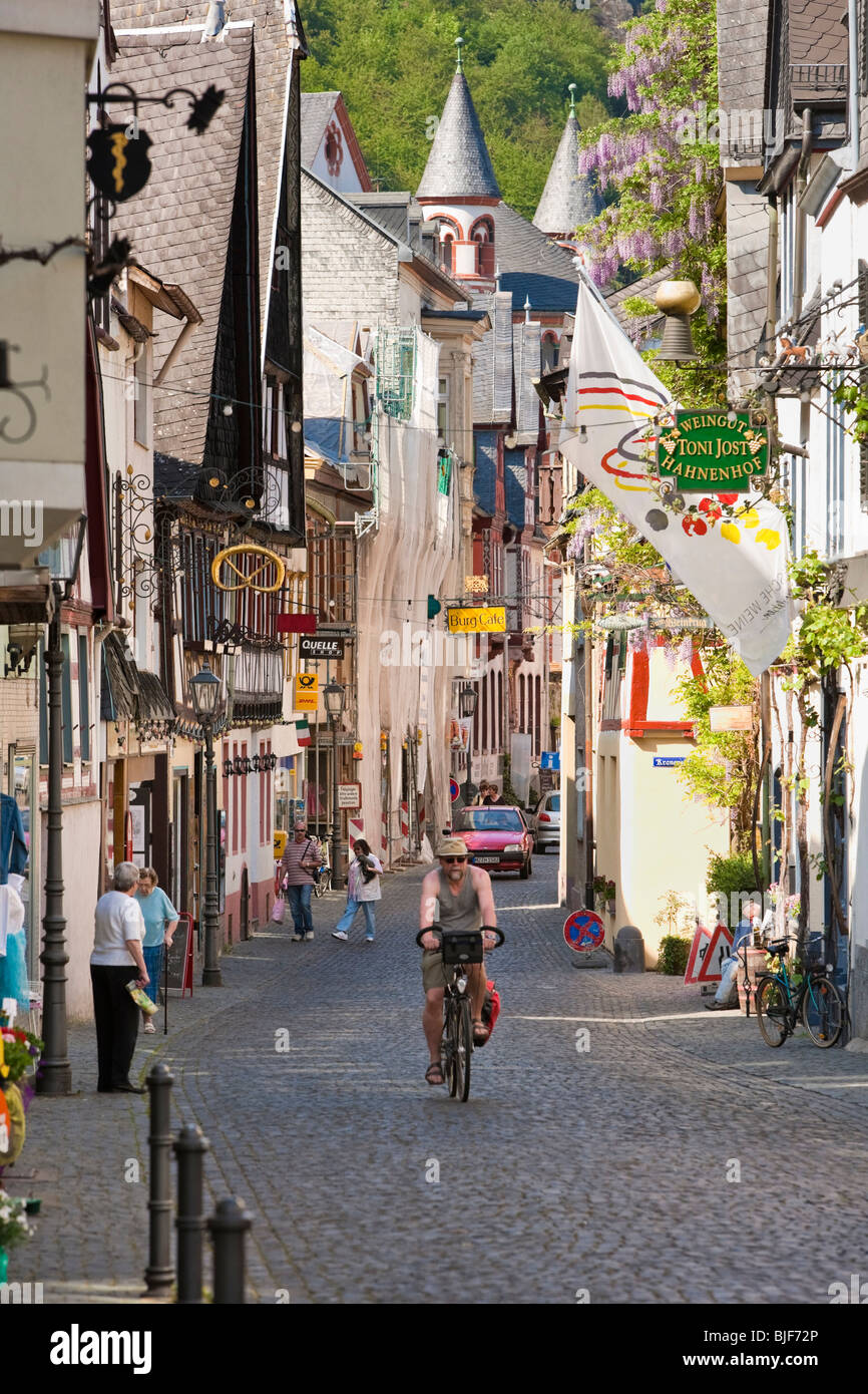 Mann, Radfahren und Menschen beim Einkaufen in Bacharach im Rheinland Deutschland - alte Straße mit Fachwerkhäusern Stockfoto