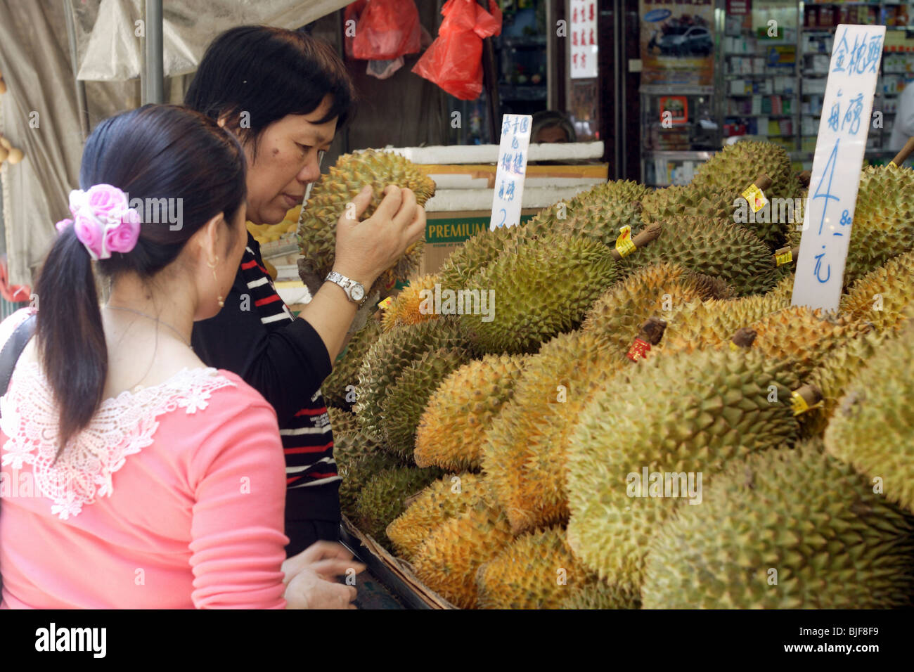 Frau riecht eine Durian Frucht, Macao, China Stockfoto