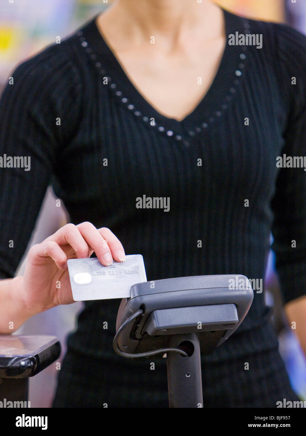 Frau streichen einer Kreditkarte Stockfoto