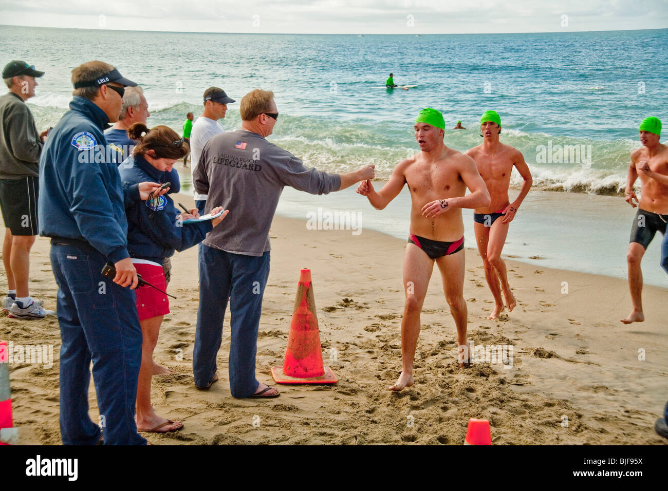 Rettungsschwimmer-Teilnehmer in Laguna Beach, Kalifornien, kommen an Land nach dem fern-qualifizierende schwimmen in kaltem Wasser 53 Grad Stockfoto