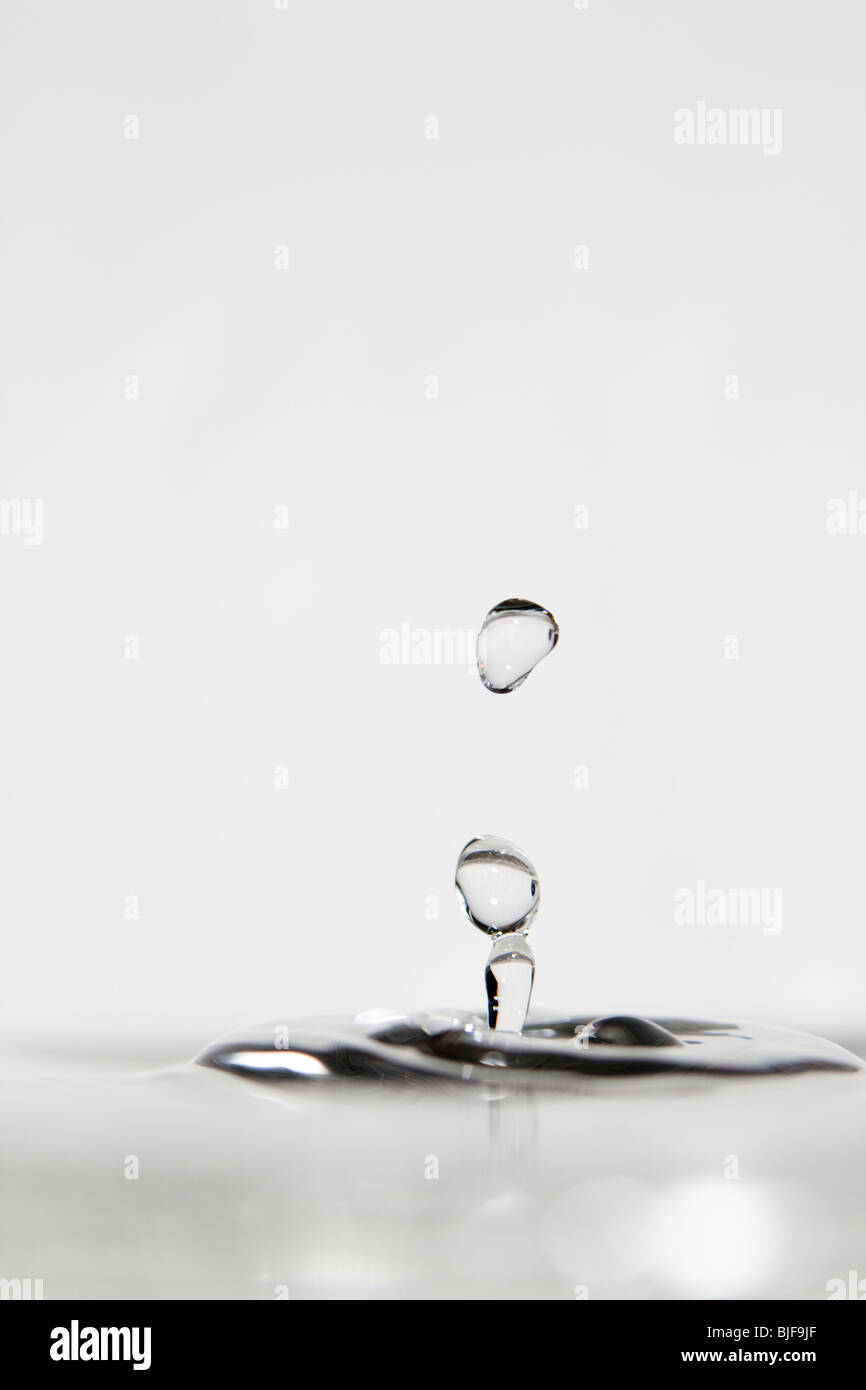 High-Speed Fotografie eines Wassertropfens von einer flachen Wasseroberfläche reflektiert. Stockfoto