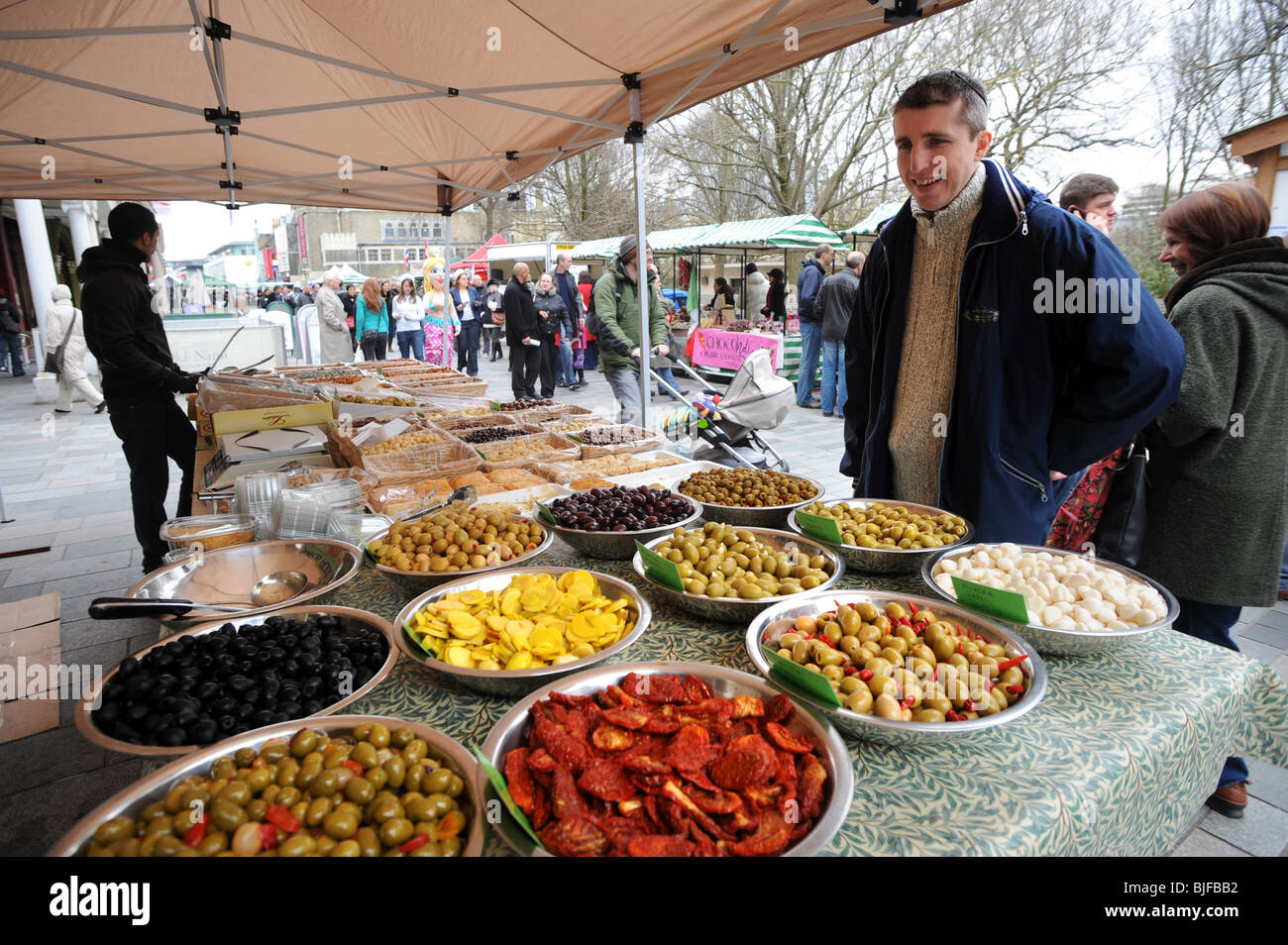 Ein Mann schaut auf einige Oliven auf einem Stall während des Brighton Essen und trinken-Festivals Stockfoto