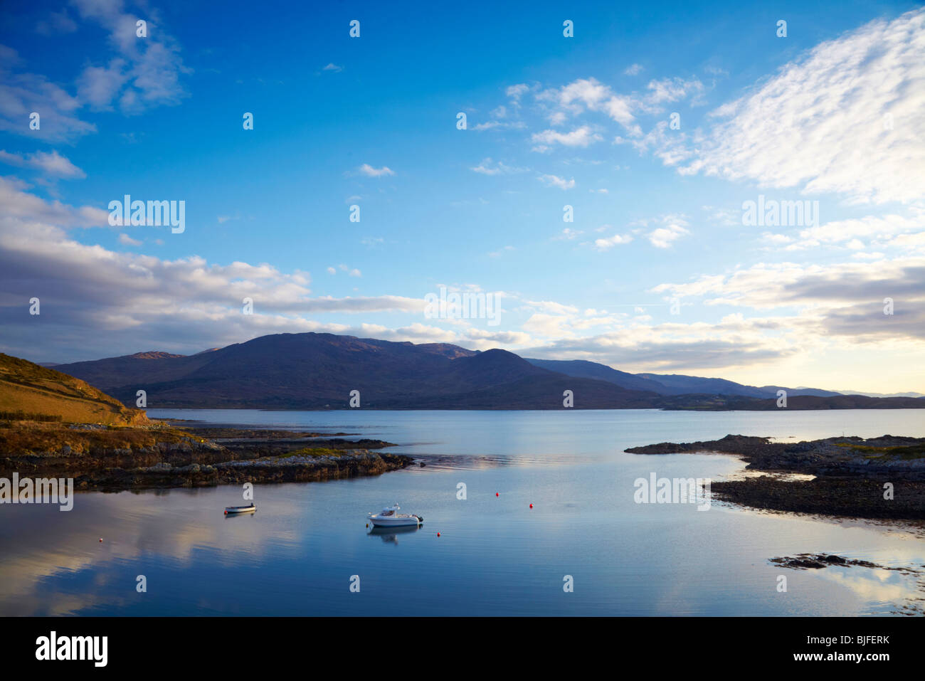 kleine Boote am Anchour in ruhigem Wasser in Kenmare River, Co.Kerry, Irland mit Bergen im Hintergrund Stockfoto