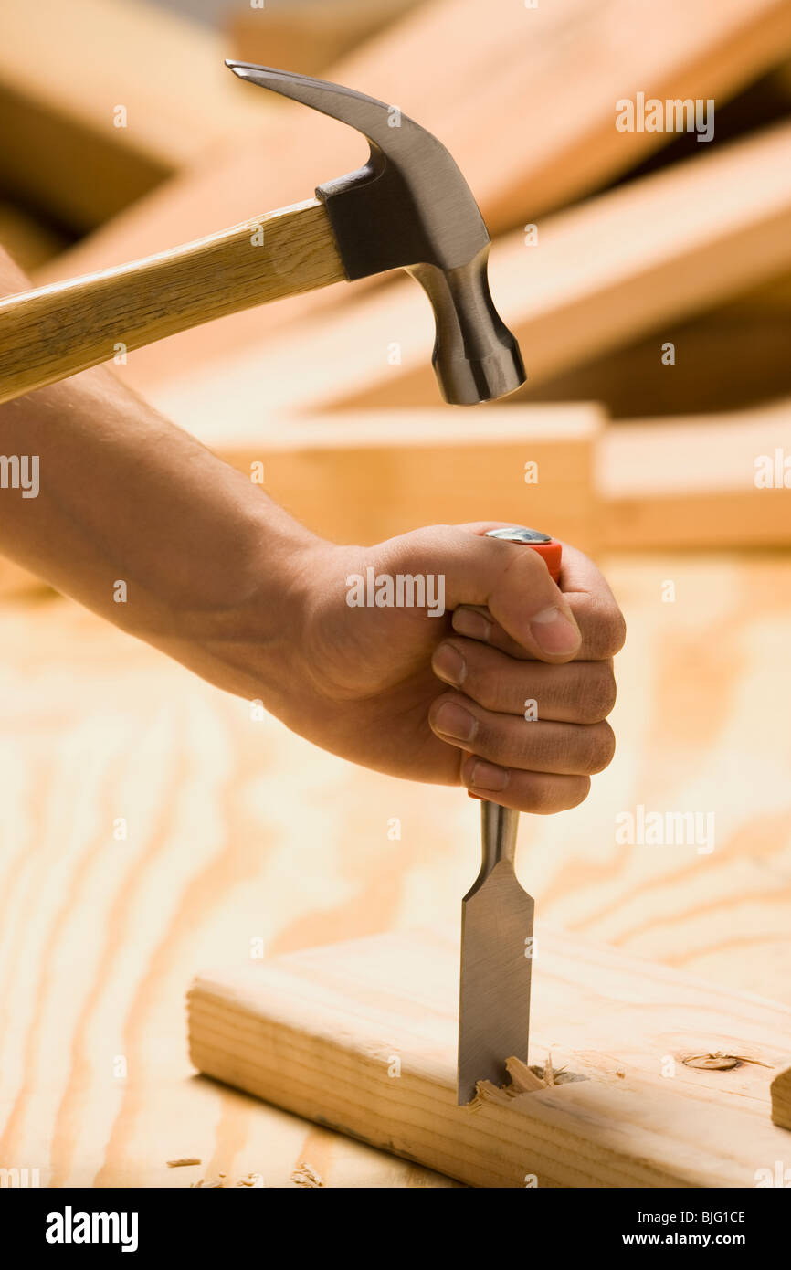 Arbeiten auf Holz mit Hammer und Meißel Stockfoto
