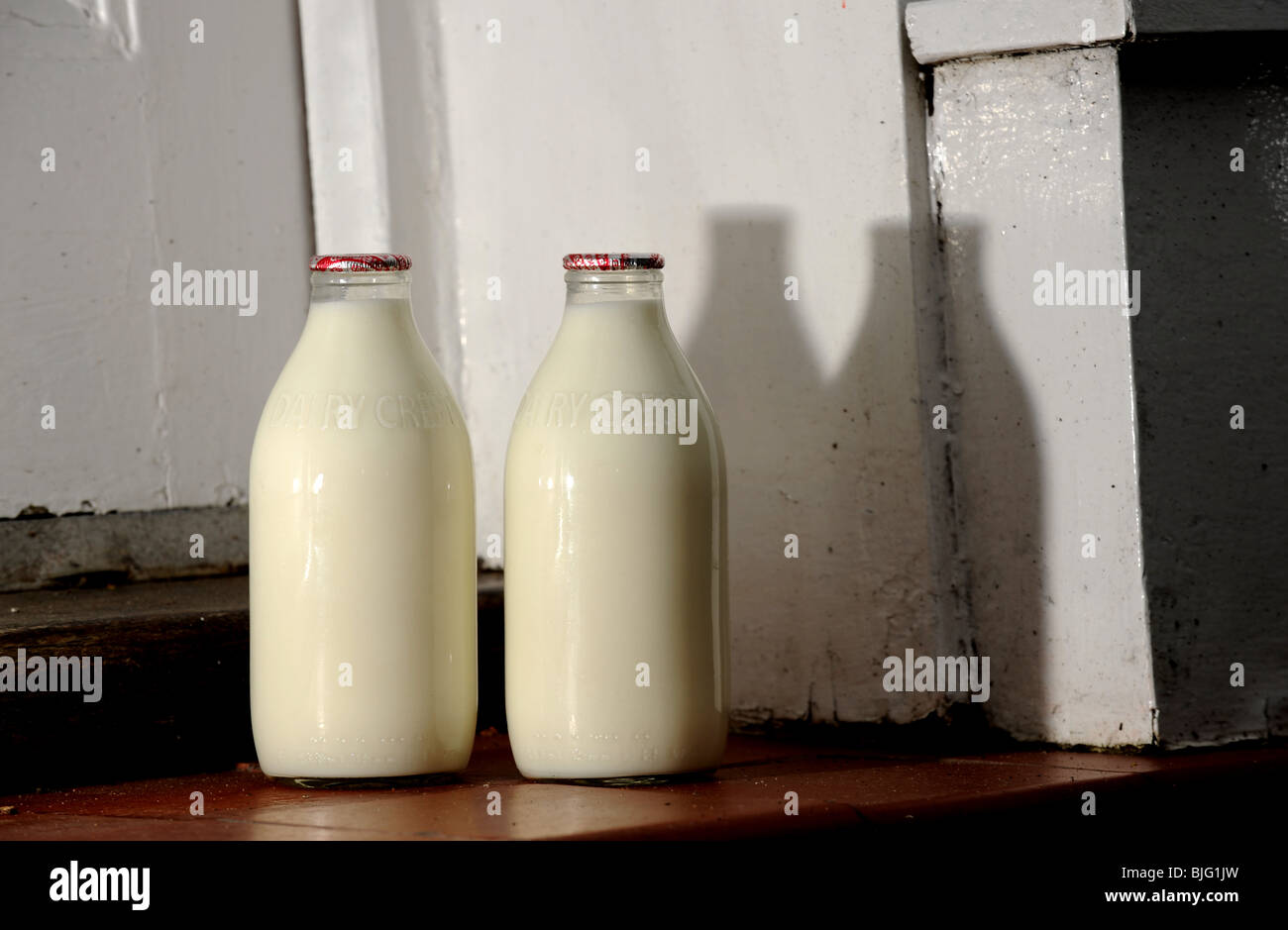 Glasflaschen von Milch auf eine Haustür von milchmann Großbritannien geliefert Stockfoto