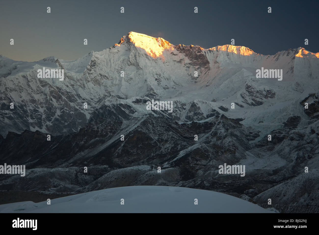 Hohen schneebedeckten Bergkette von ersten Sonnenstrahlen beleuchtet Stockfoto