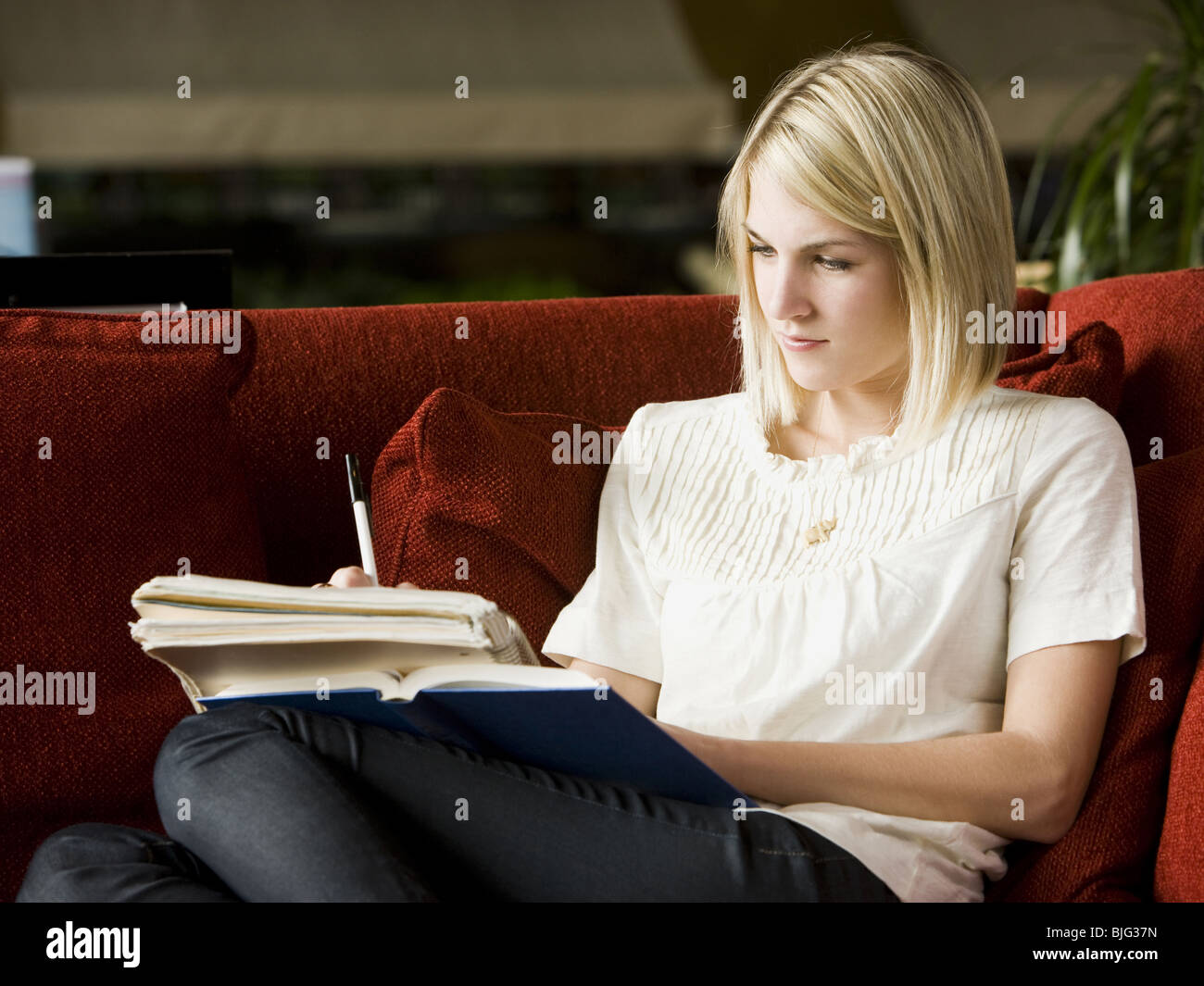 Frau liest auf der couch Stockfoto