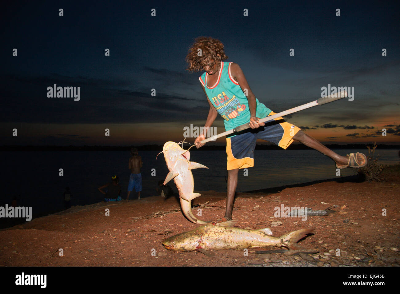 Aborigines Boy zeigt seinen Angeln Erfolg, dass ein Wels vom Fluss Blythe auf Gamardi Schule "Fishing Expedition" erwischt Stockfoto