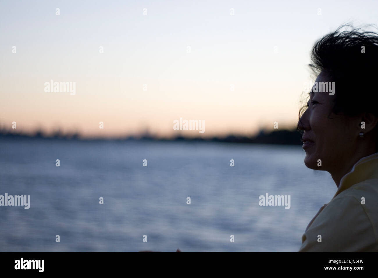 Eine orientalische Frau schaut aus einem Boot im Hafen von Sydney. Stockfoto