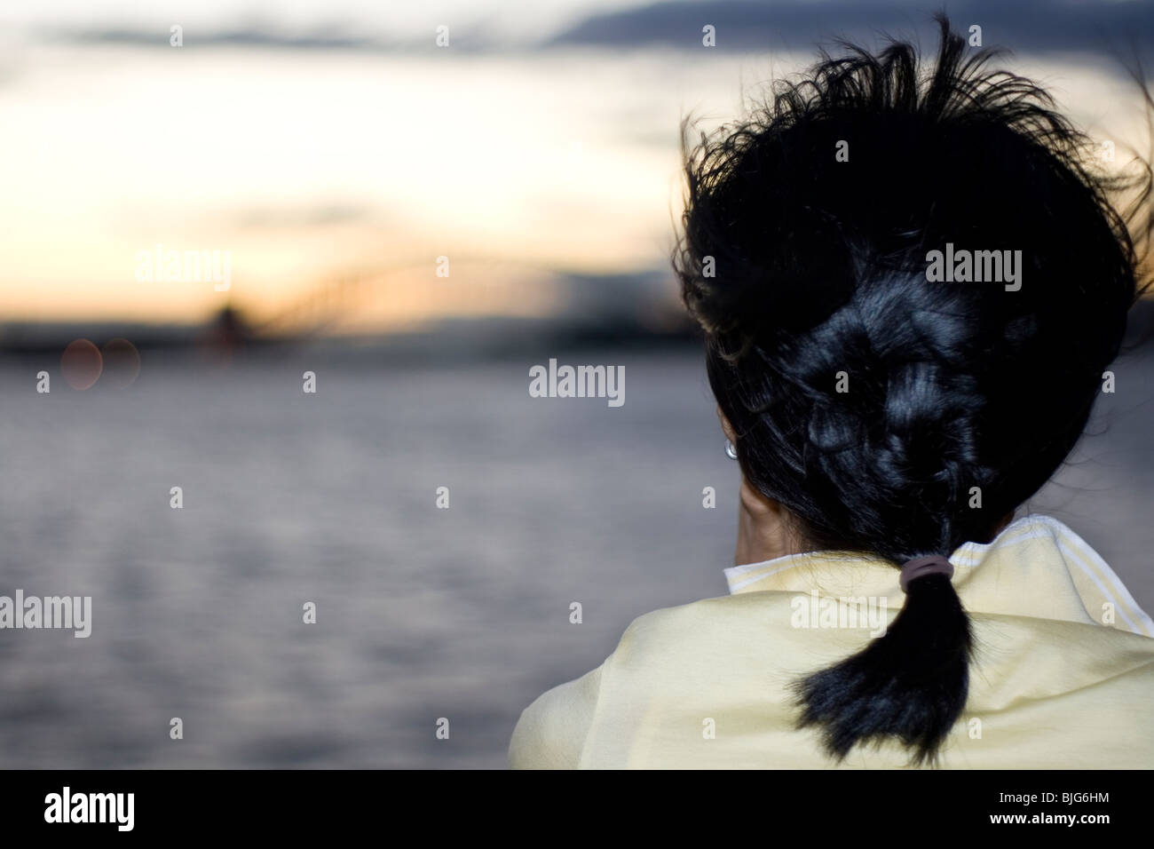 Eine orientalische Frau schaut aus einem Boot im Hafen von Sydney. Stockfoto