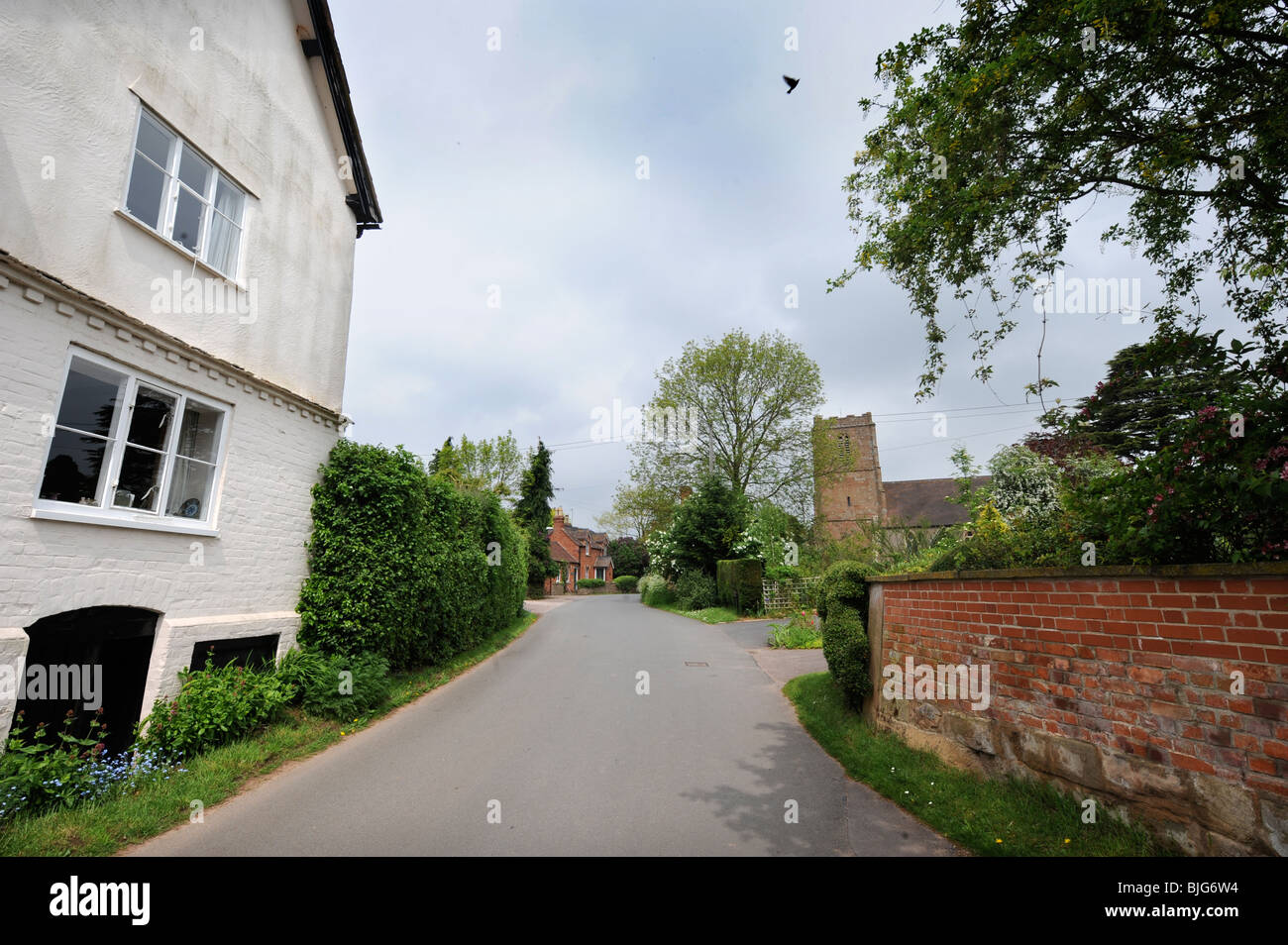 Eine Gasse durch das Dorf Redmarley D'Abitot, Gloucestershire mit der Kirche von St. Bartholomäus Stockfoto