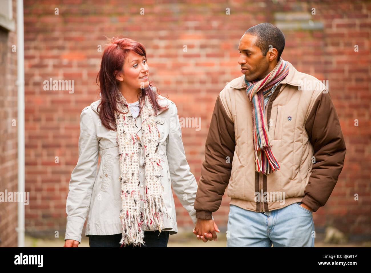 Junge interracial paar walking und Lächeln verliebt. VOLL-MODELL VERÖFFENTLICHT Stockfoto