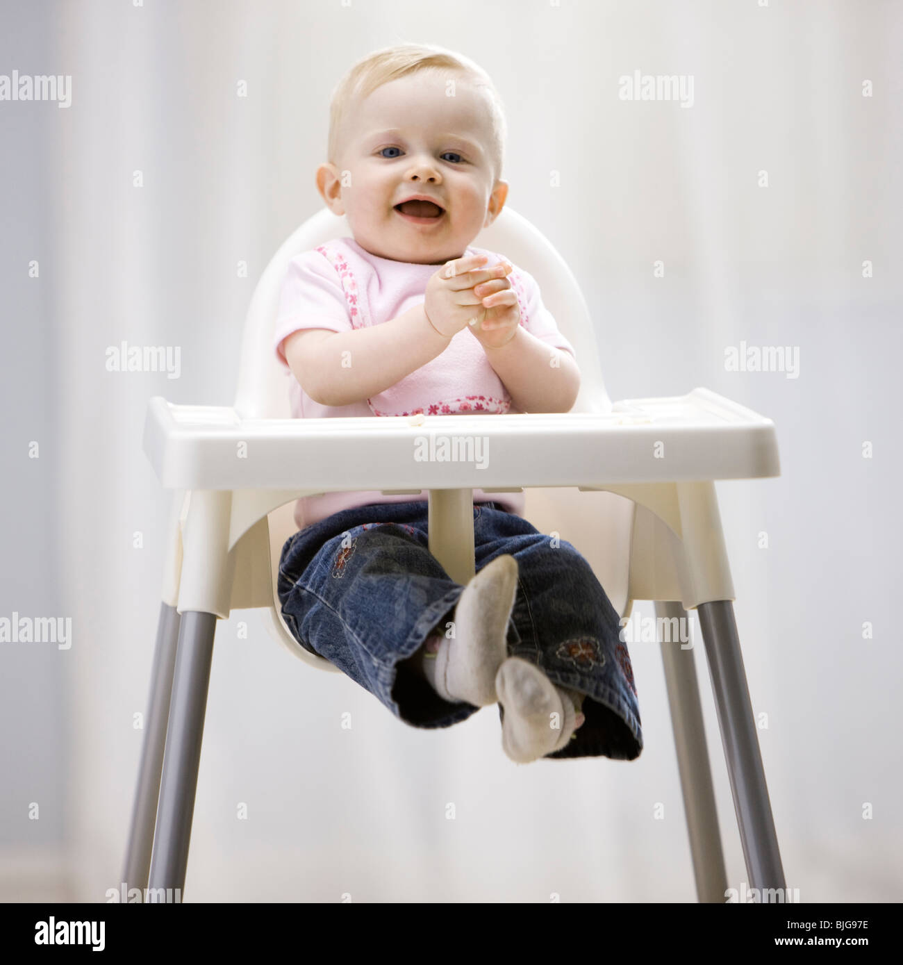 Babymädchen in einen Hochstuhl Stockfoto