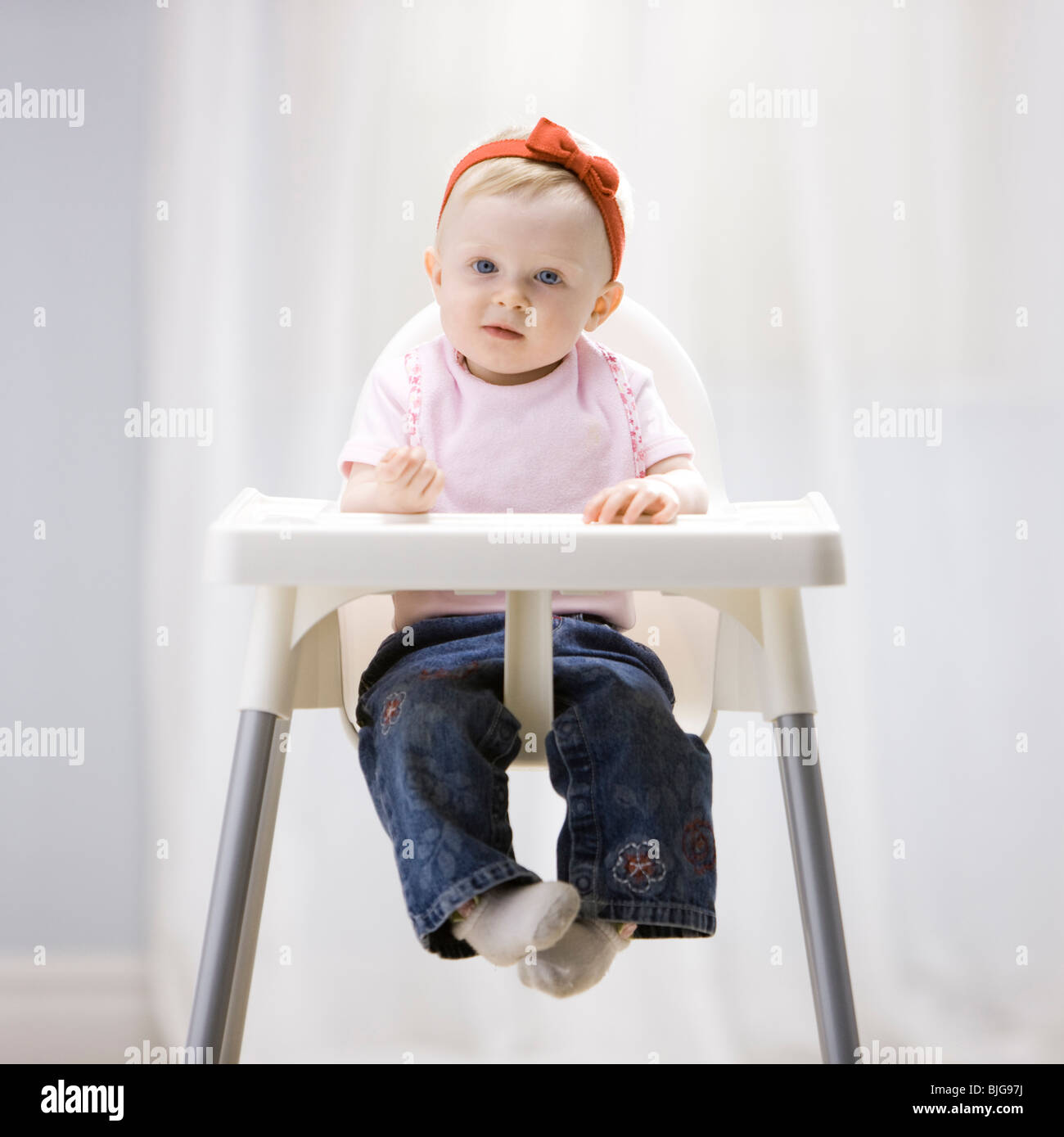 Babymädchen in einen Hochstuhl Stockfoto