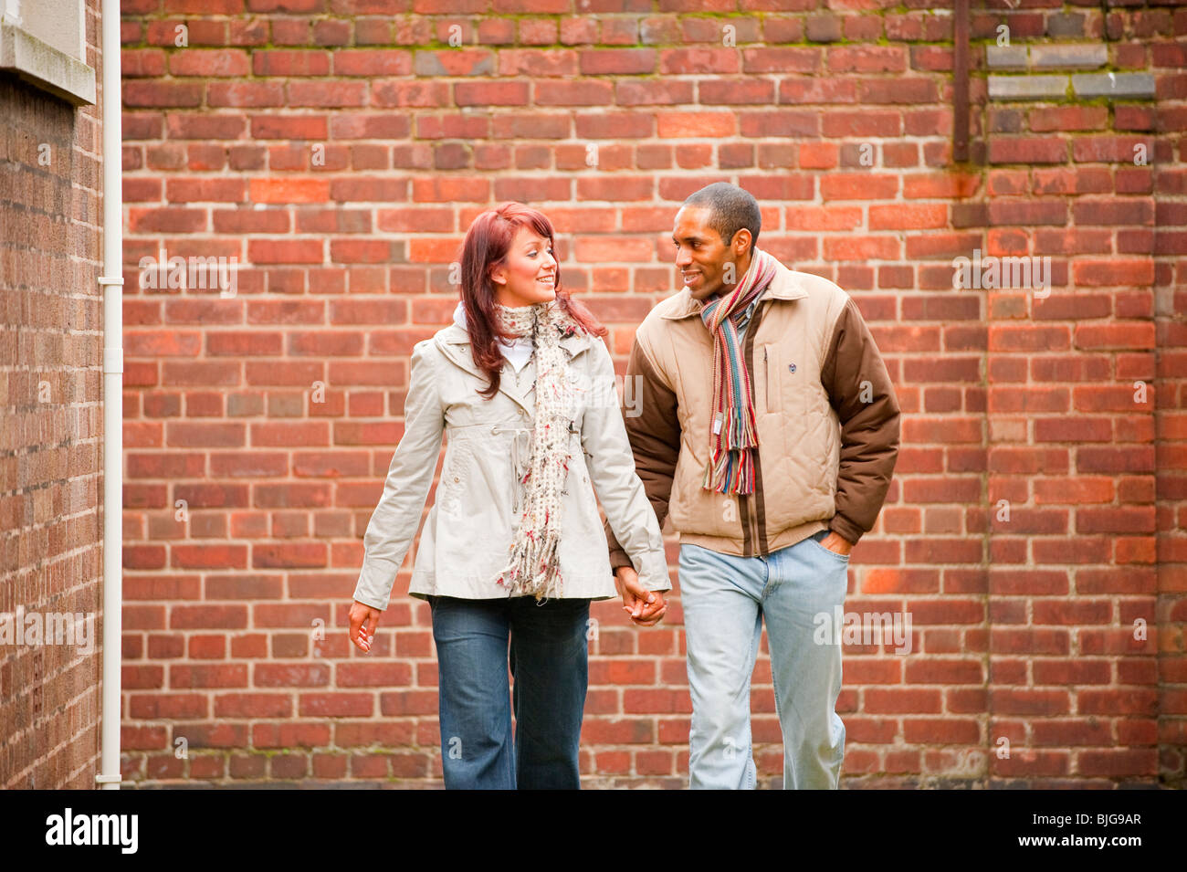 Junge interracial paar walking und Lächeln verliebt. VOLL-MODELL VERÖFFENTLICHT Stockfoto
