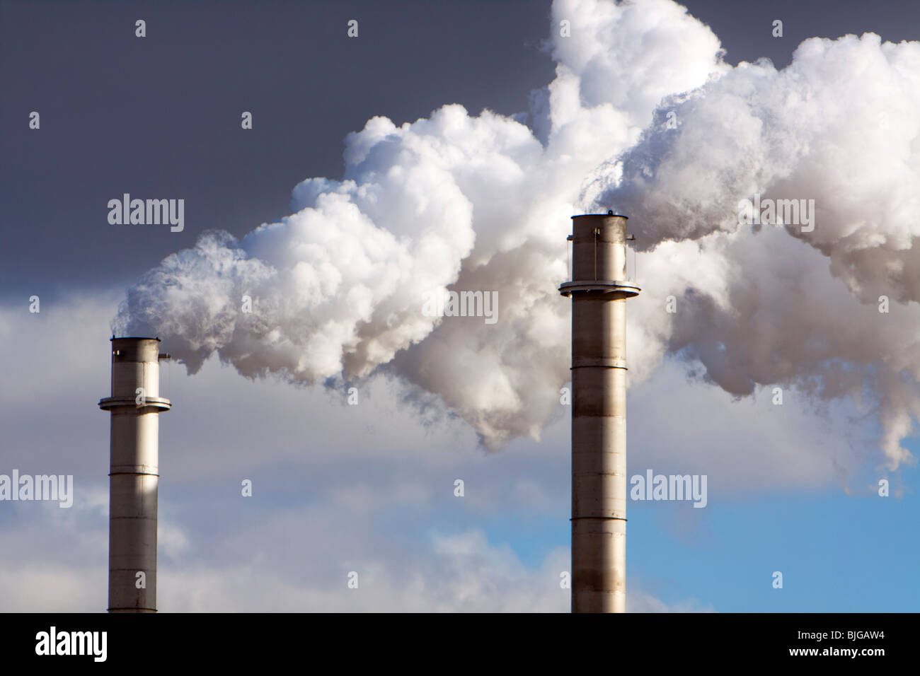 Ein Schornstein wabert Rauch und Dampf im ländlichen Nebraska. Schuss aus öffentlichen Straßen. Stockfoto