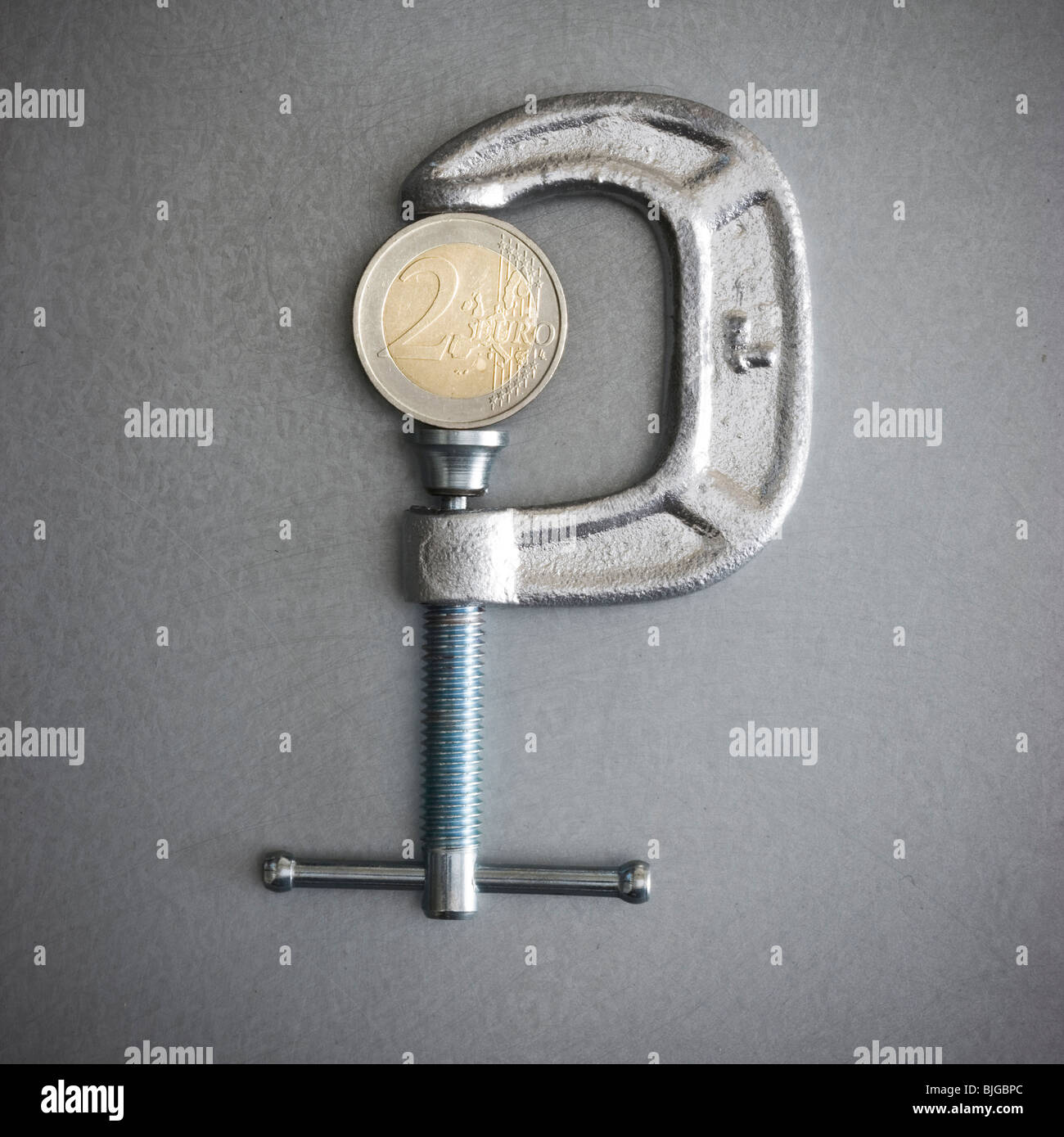 zwei-Euro-Münze in einer Klemme Stockfoto