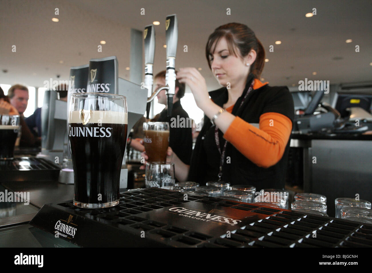 Frau tippt Guinness Bier in einer Bar, Dublin, Irland Stockfoto