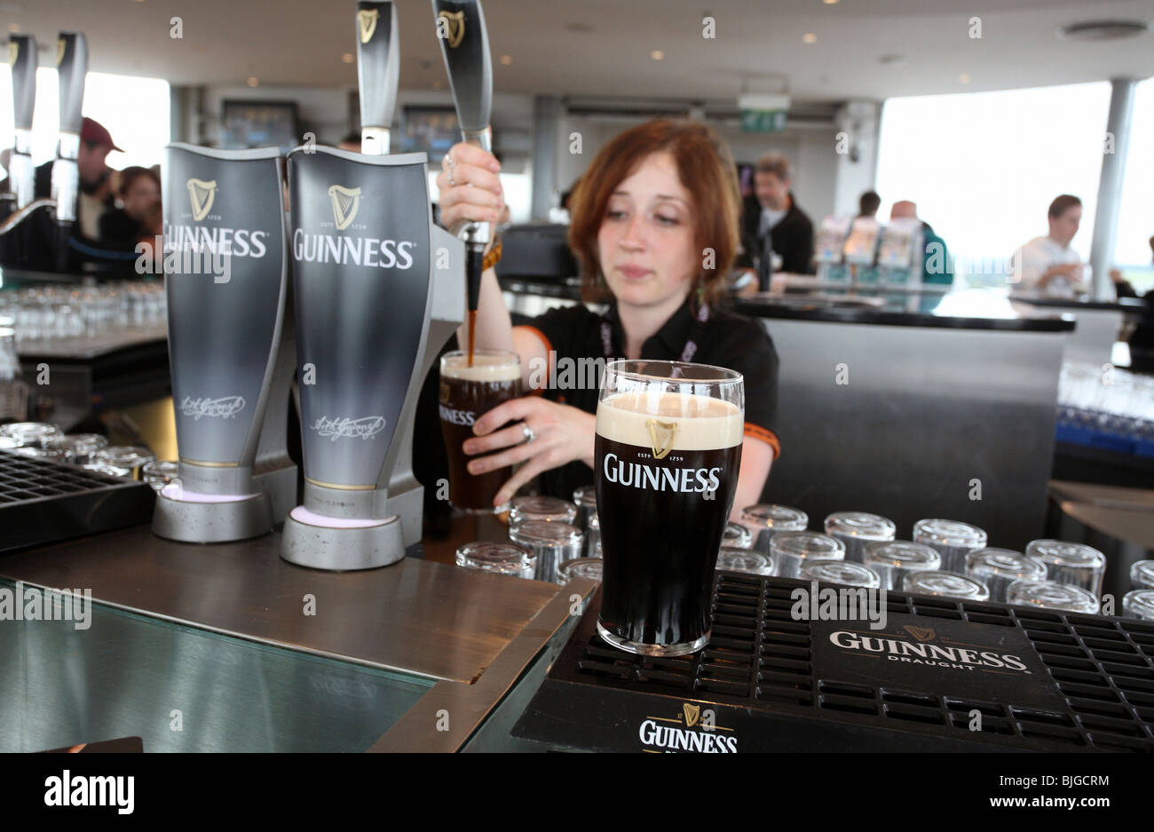 Frau tippt Guinness Bier in einer Bar, Dublin, Irland Stockfoto