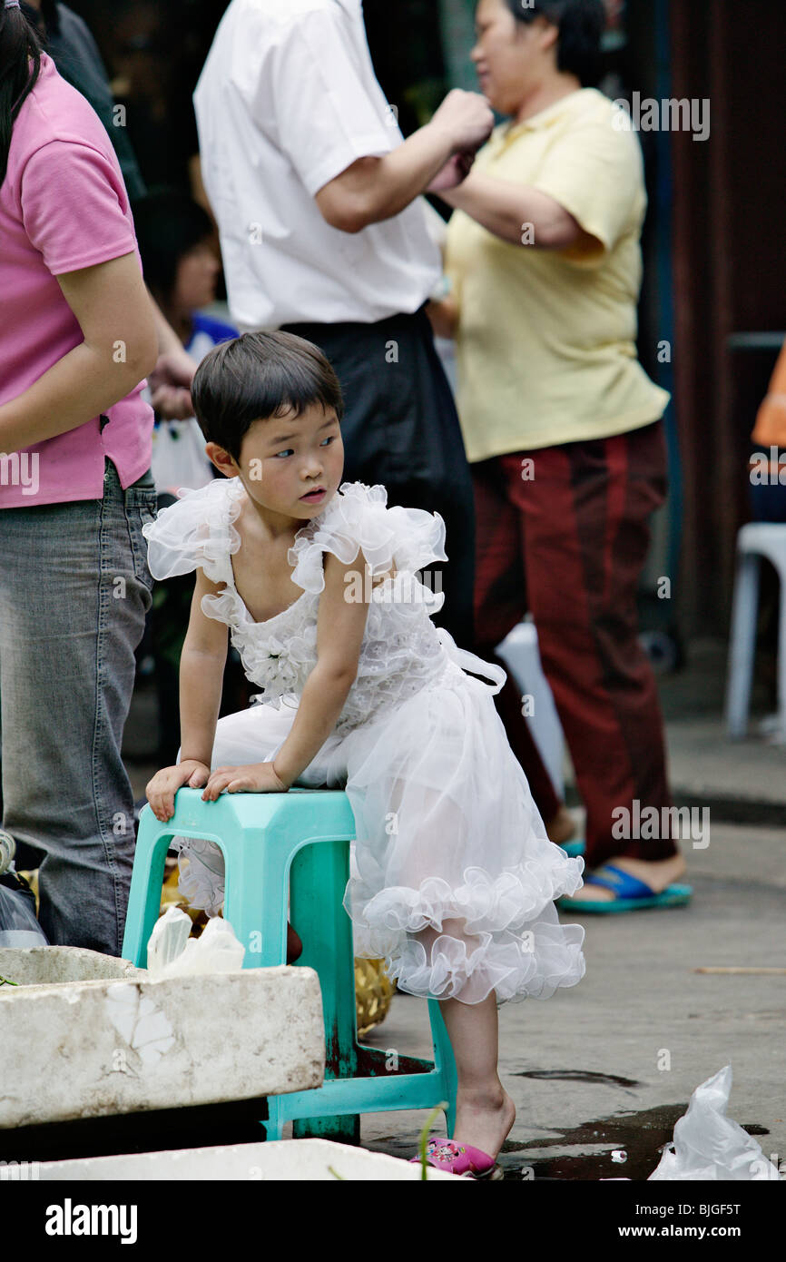 Kleines Mädchen mit Kostüm auf einer kleinen Gasse der Altstadt Shanghais. Stockfoto