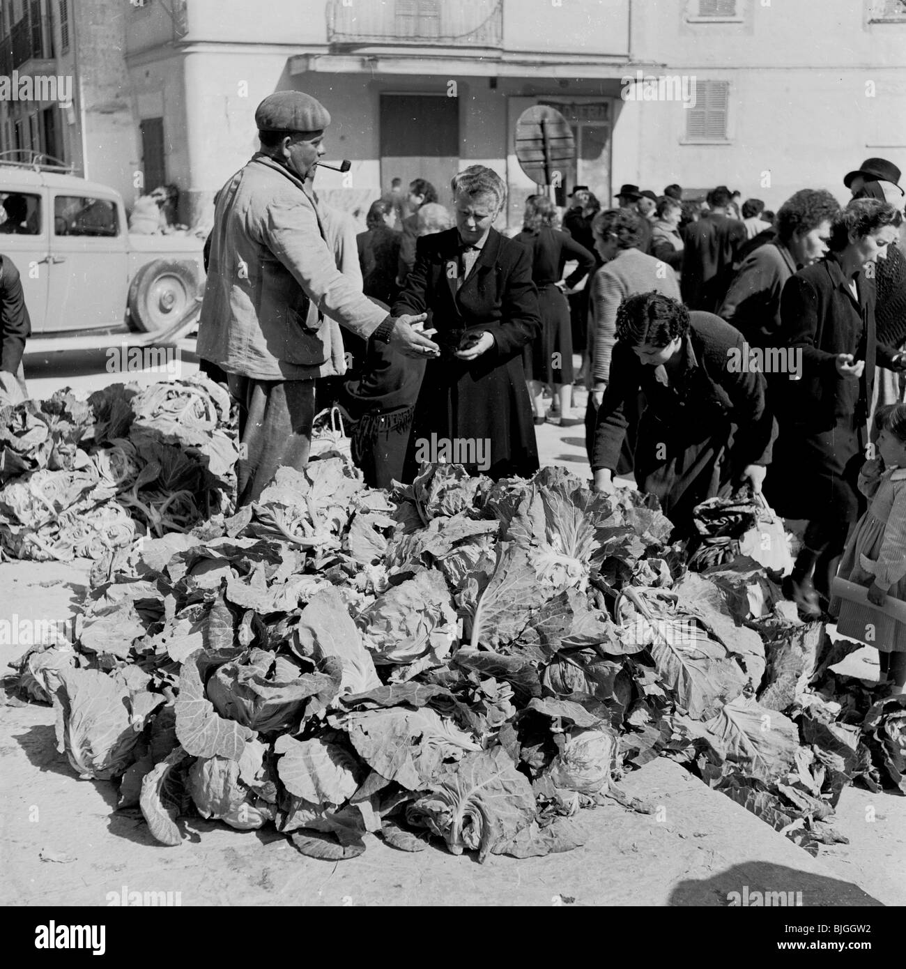 der 1950er Jahre in dieses Geschichtsbild durch J Allan Cash, einer spanischen Markt Händler in Straße Pfeife zeigt Kunden seinen Kohl. Stockfoto