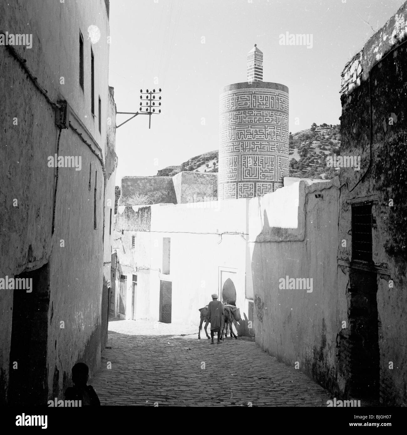 der 1950er Jahre in diesem Geschichtsbild begleichen Sonnenlicht und Schatten über Teile von einem ummauerten Dorf Sidestreet, Marokko. Stockfoto