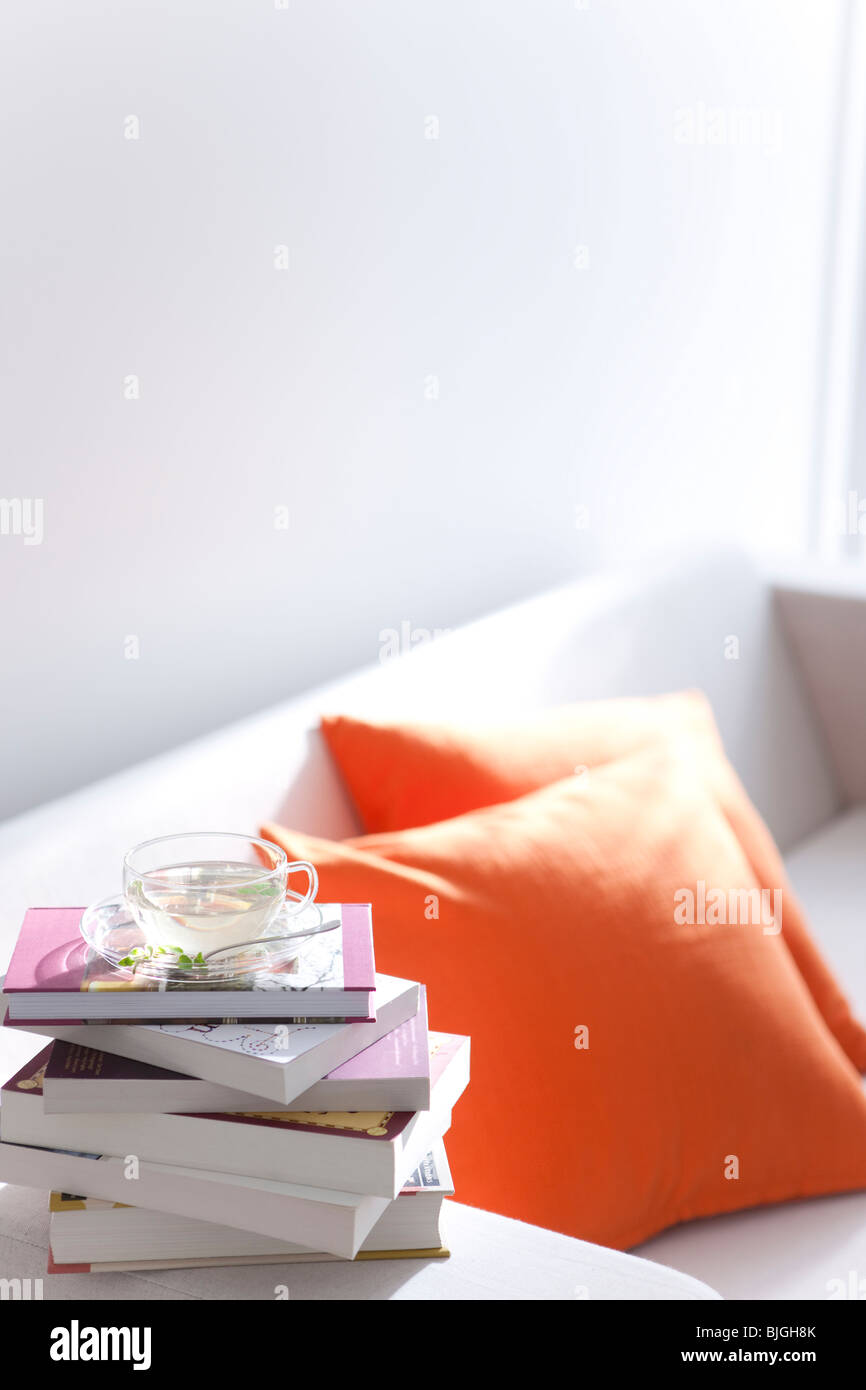 Kräutertee und einen Stapel Bücher auf einem Sofa Stockfoto