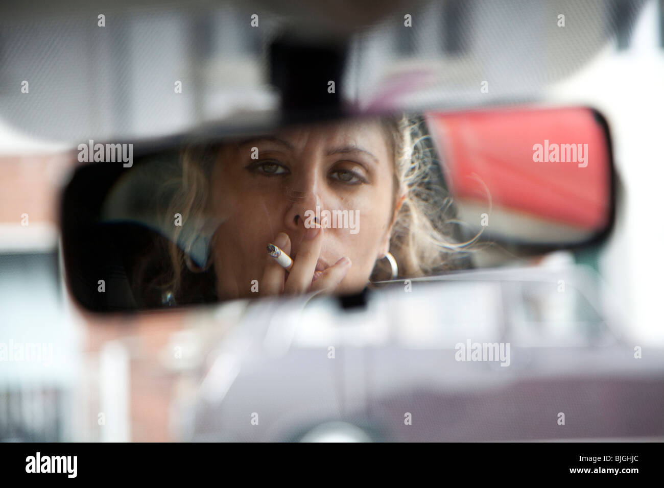 Frau Rauchen Zigarette im Auto. Ärzte in Großbritannien fordern ein Verbot des Rauchens in Autos. Stockfoto