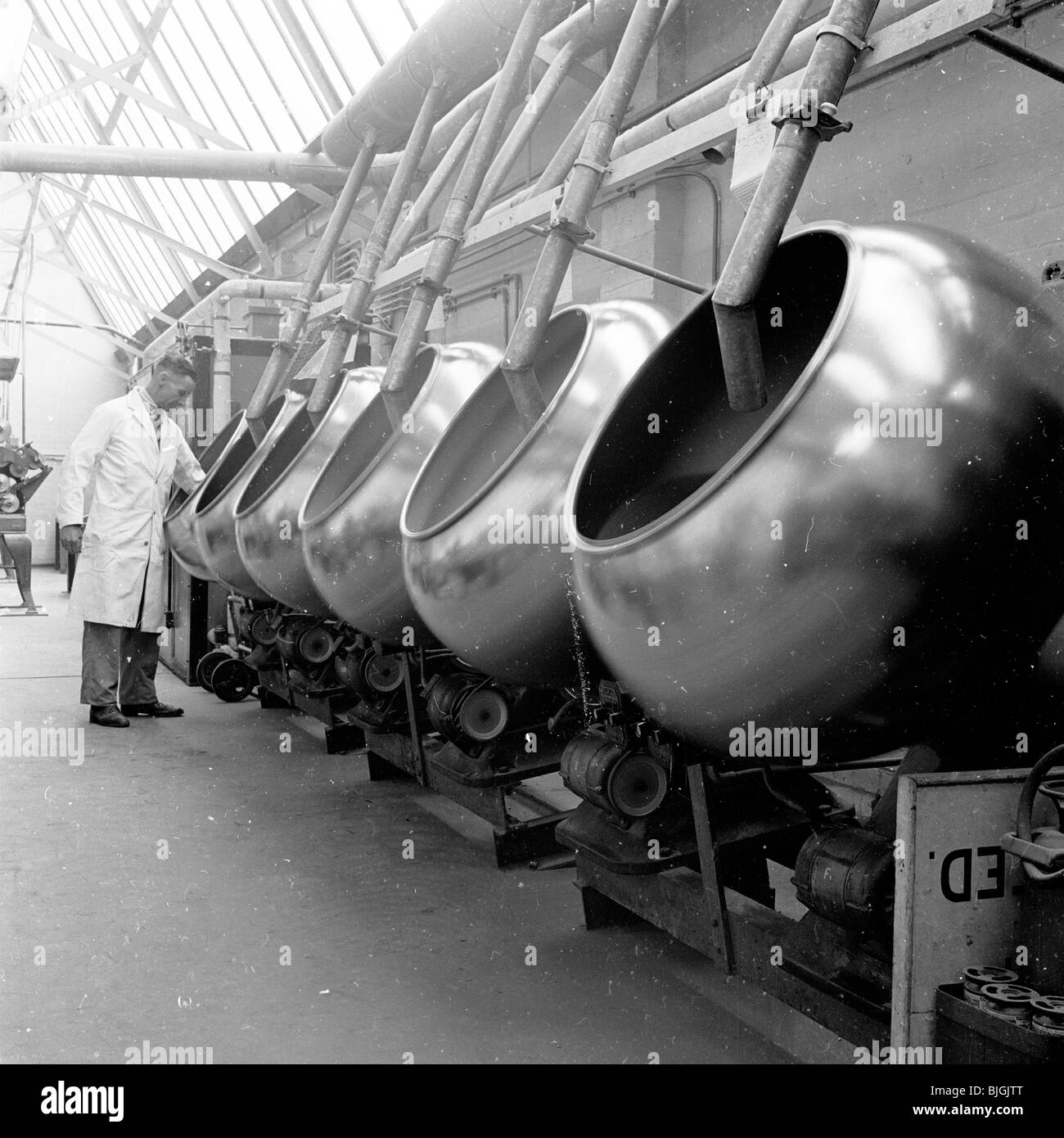 1950er Jahren England. Betriebsleiter Produktion prüft auf Zeile von großen Stahlfässern an medizinischen Produktionsgesellschaft, Arthur H.Cox & Co Stockfoto