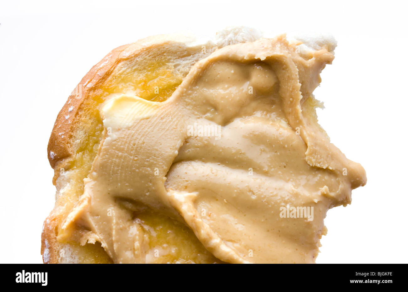 Glatte Erdnussbutter auf warmen Buttertoast isoliert vor weißem Hintergrund. Stockfoto