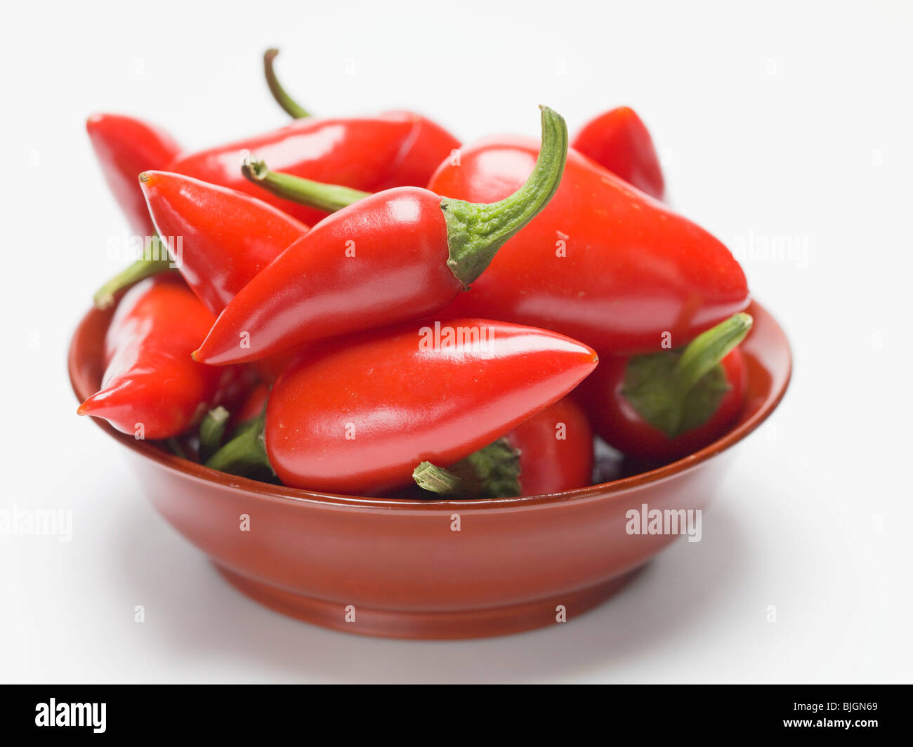 Rote Chilis in einer roten Schale- Stockfoto