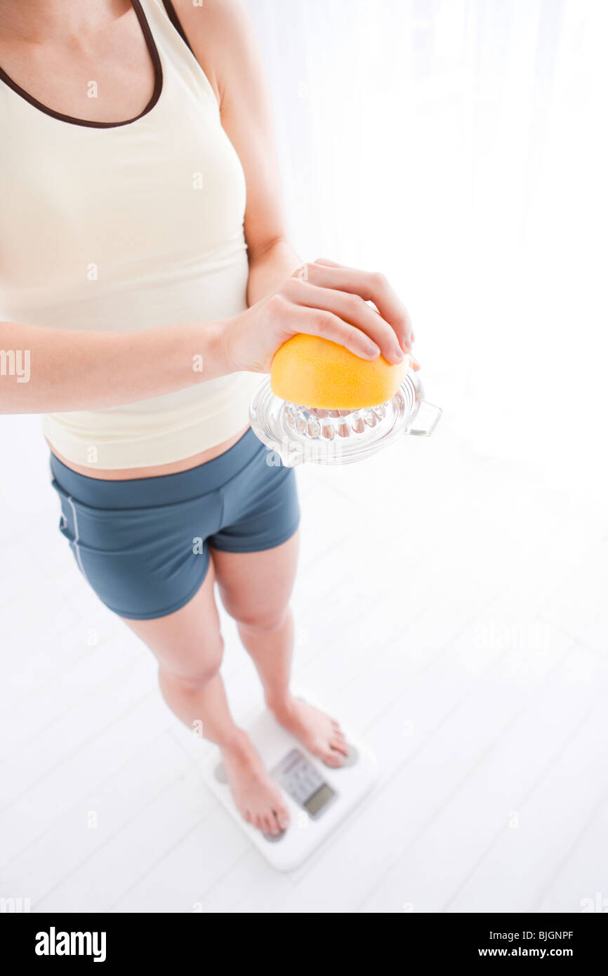 Frau, die sich auf Personenwaage wiegen Stockfoto