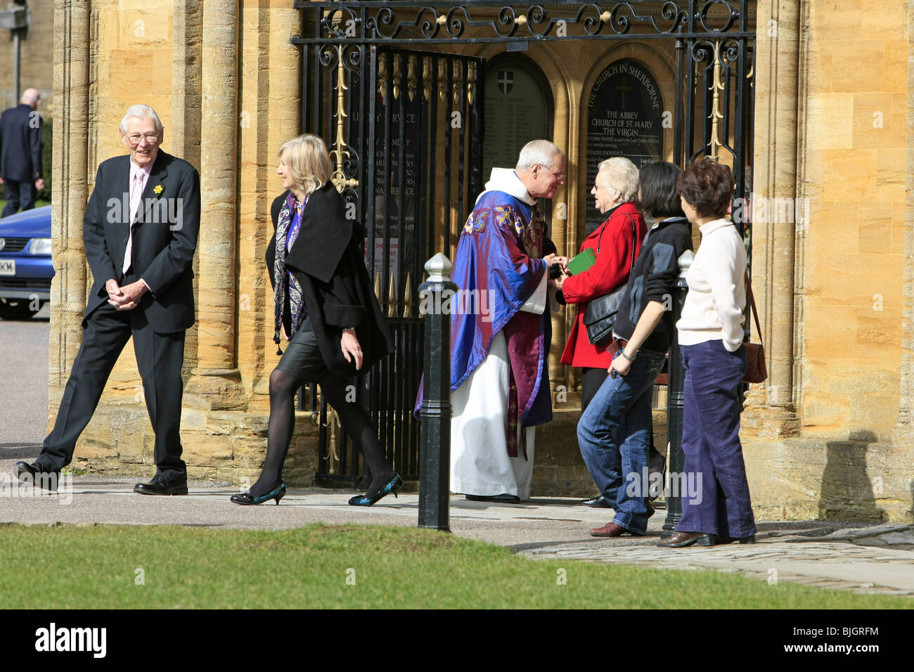 Menschen verlassen den sonntäglichen Gottesdienst in Sherborne Abbey wird durch den Pfarrer für Ihr kommen zum Anhören seiner Predigt dankte. Stockfoto