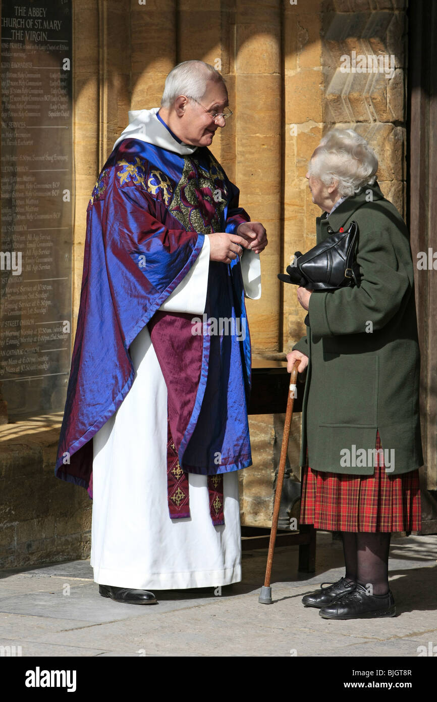 Menschen verlassen den sonntäglichen Gottesdienst in Sherborne Abbey wird durch den Pfarrer für Ihr kommen zum Anhören seiner Predigt dankte. Stockfoto