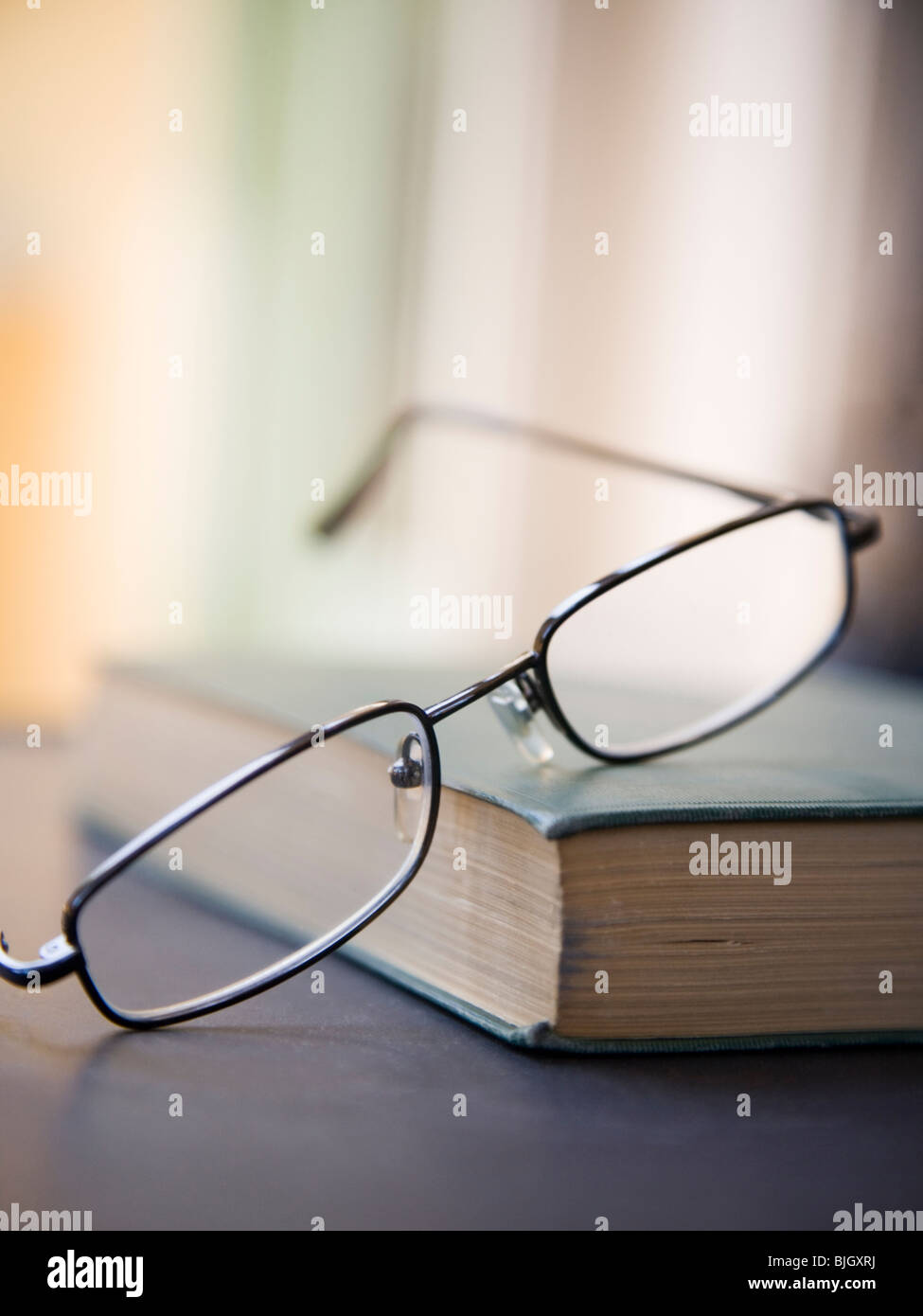 Brille an einem Buch Stockfoto