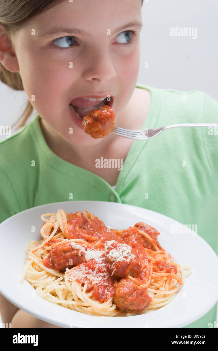 Mädchen essen Spaghetti mit Fleischbällchen- Stockfoto