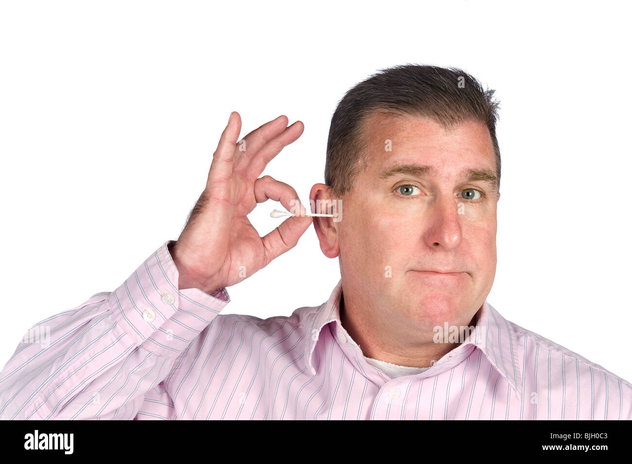 Ein Mann mittleren Alters reinigt sein Ohr mit einem Wattestäbchen. Stockfoto