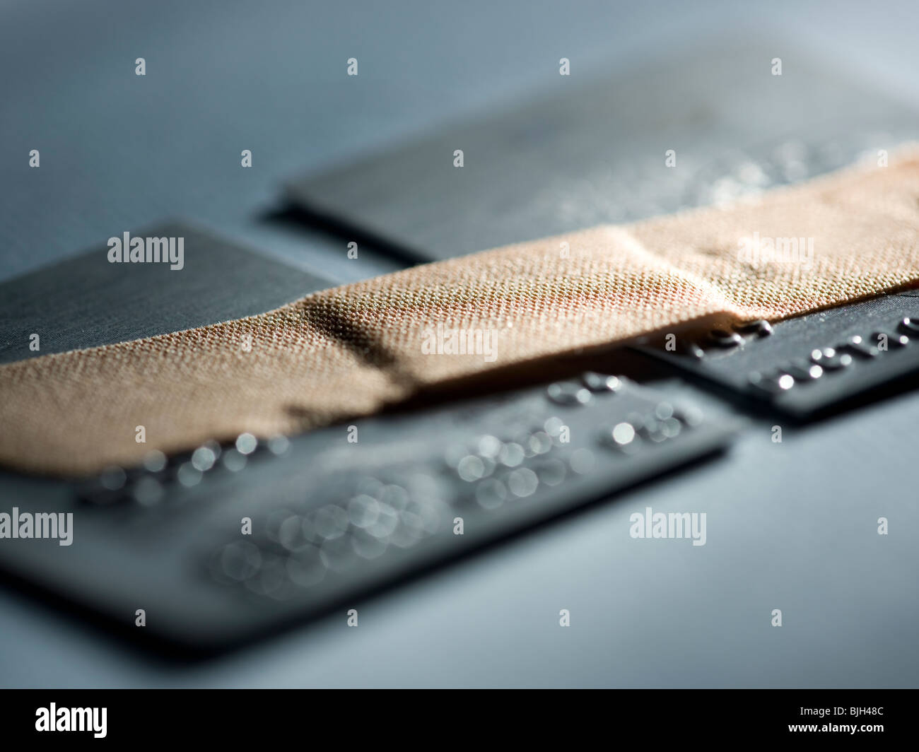 Kreditkarte in zwei Hälften mit einem Pflaster halten sie zusammen geschnitten Stockfoto