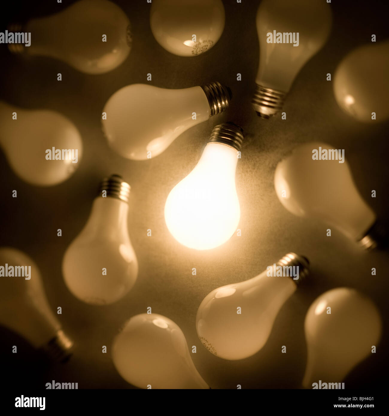 eine Glühbirne leuchtet unter vielen Stockfoto