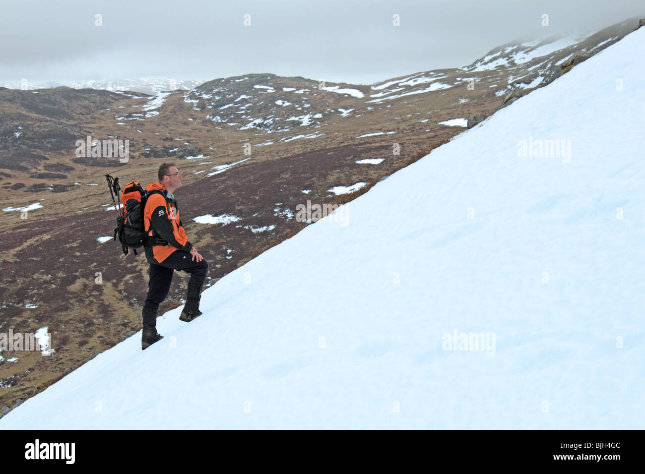 Einsamer Wanderer steigt Schnee-beklebt Cadair Idris über die steilen und instabilen Fox Weg, Snowdonia-Nationalpark, Gwynedd, Wales, UK Stockfoto