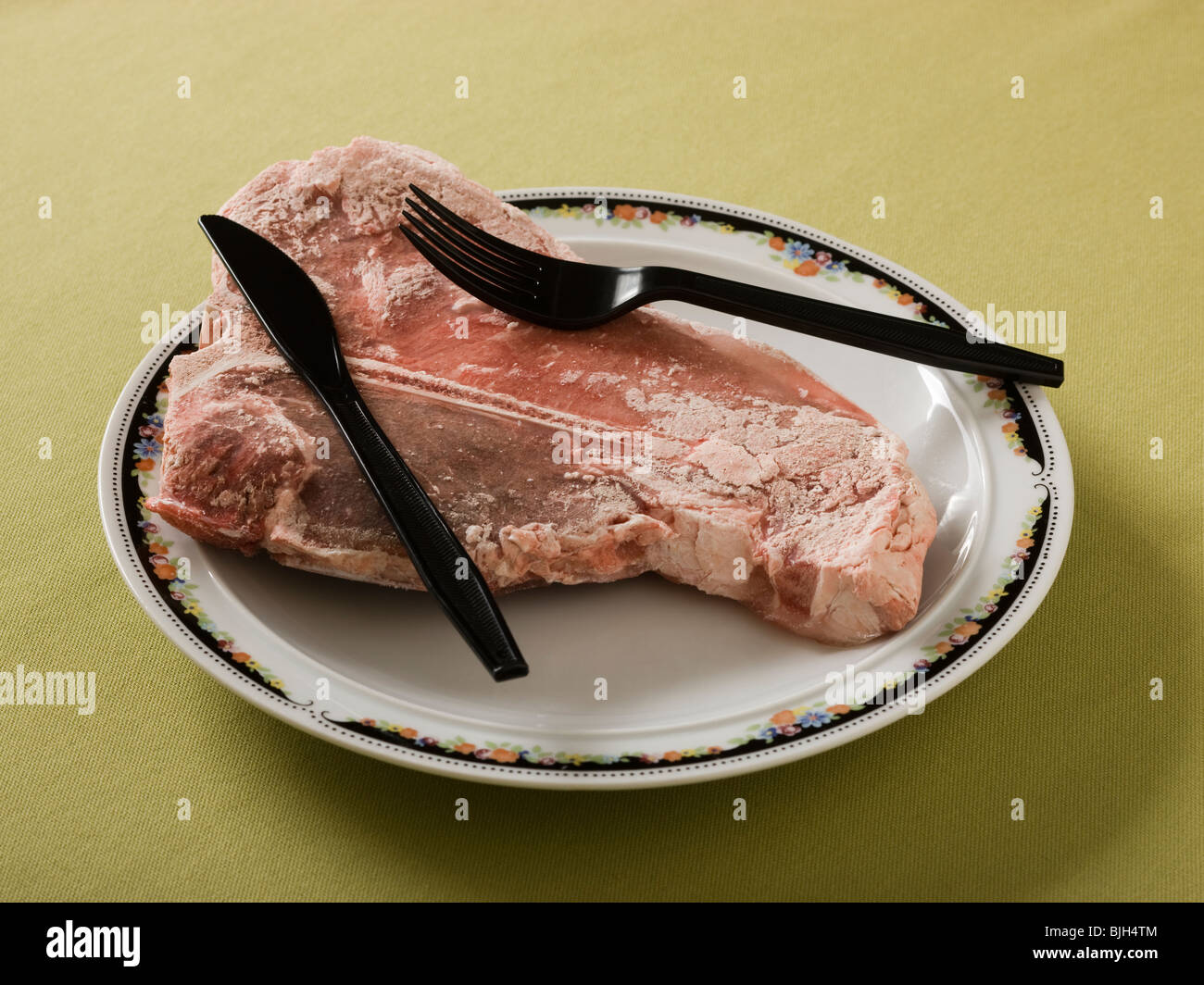 gefrorenes rohes Steak auf einem Teller serviert wird Stockfoto