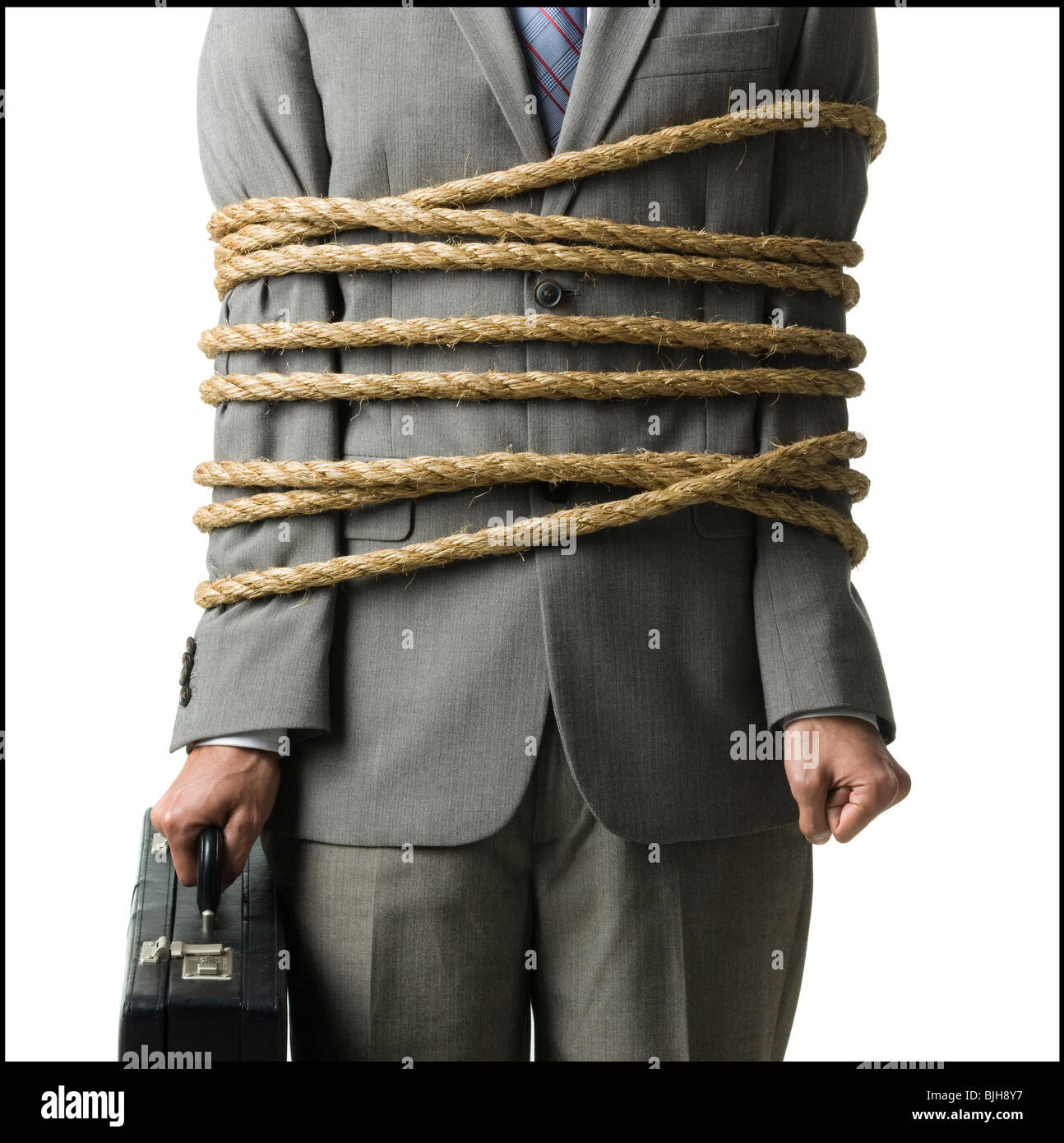 Geschäftsmann in einem vollen Anzug gefesselt mit einem Seil um seine Mitte Abschnitt Stockfoto