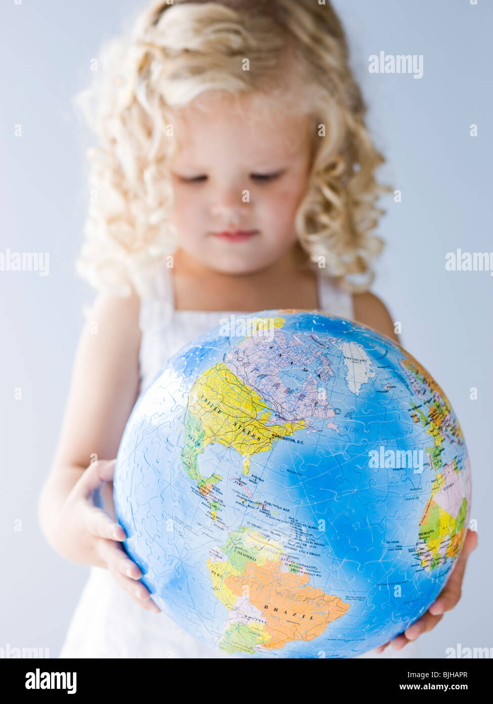 kleines Mädchen hält einen Globus Stockfoto