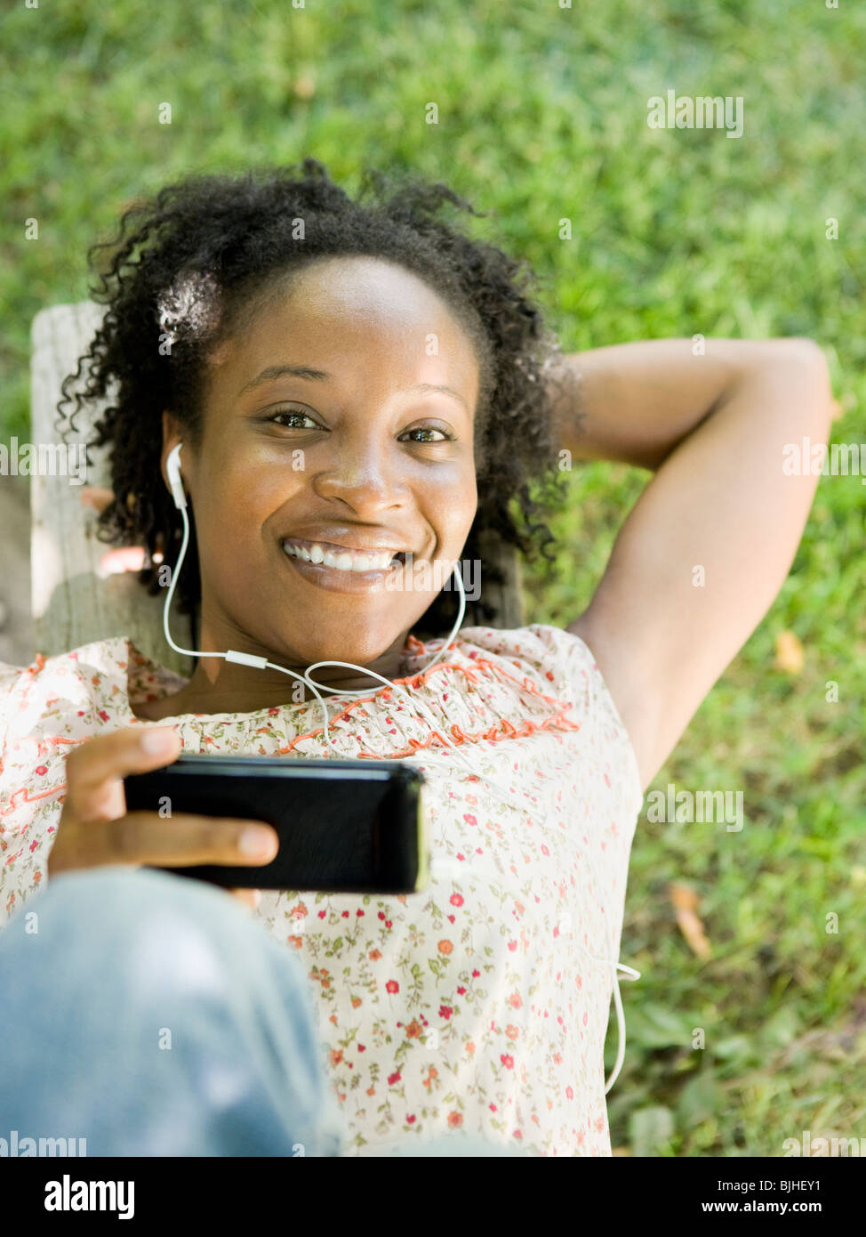 Frau im Hinterhof eines digitalen Musik-Player anhören Stockfoto