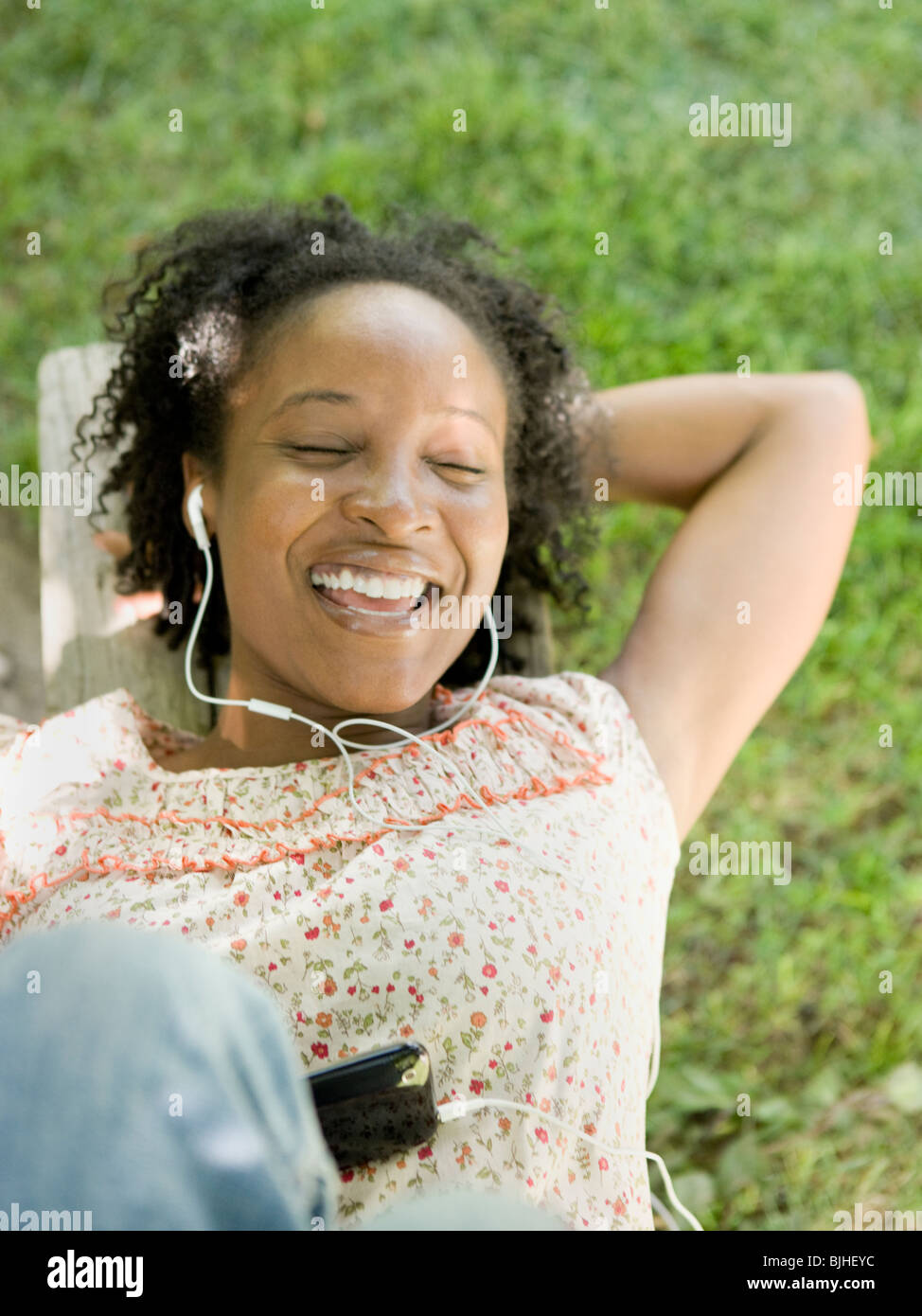 Frau im Hinterhof eines digitalen Musik-Player anhören Stockfoto