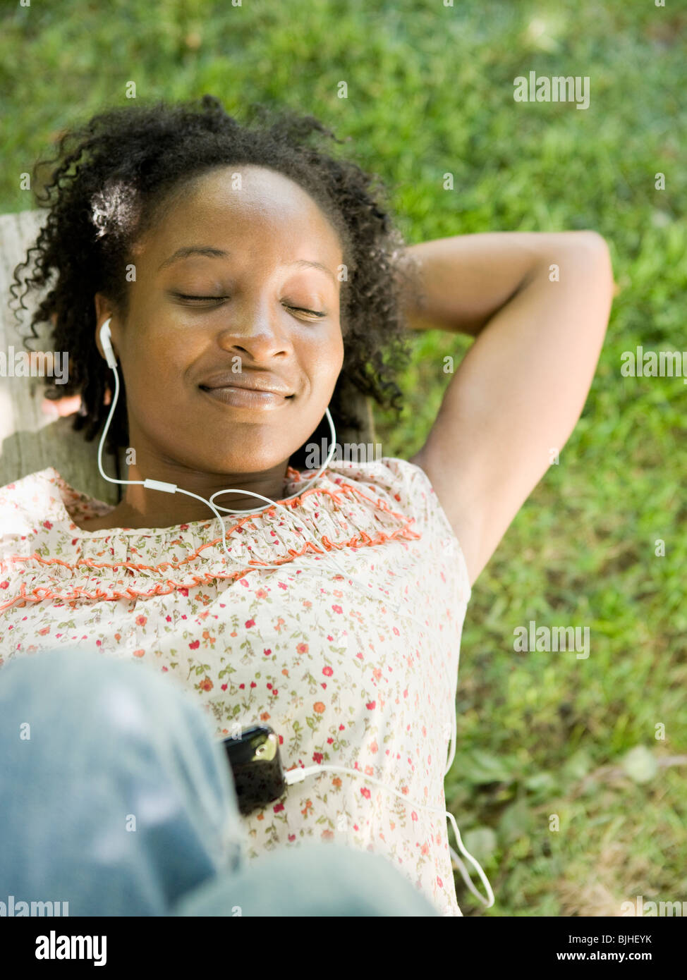 Frau im Hinterhof eines digitalen Musik-Player anhören Stockfoto